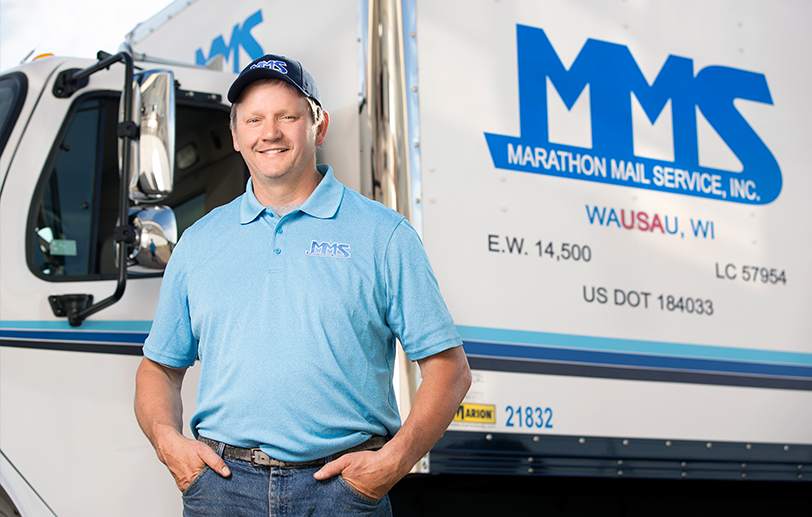 Marathon Mail representative standing in front of a truck