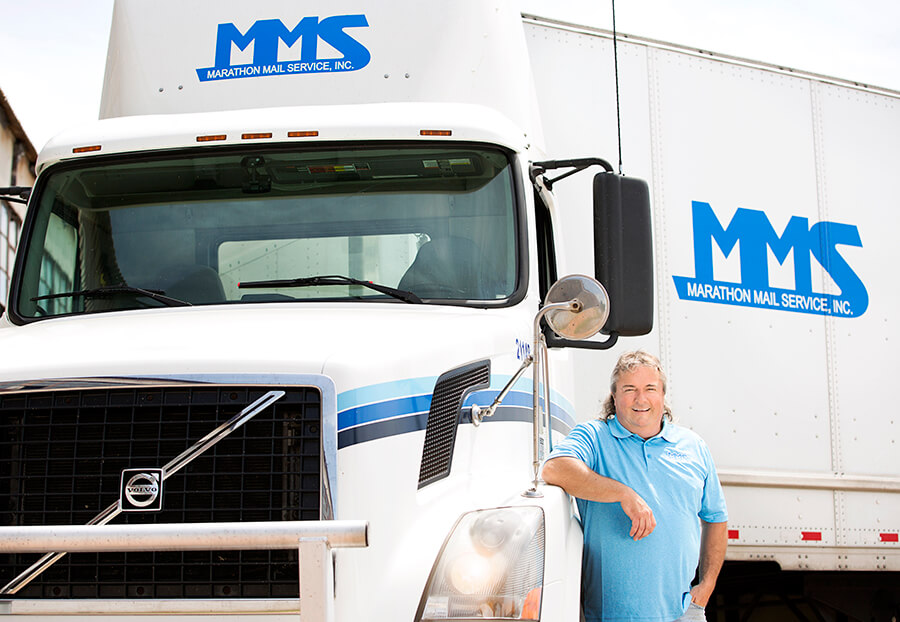 MMS Driver standing in front of a truck
